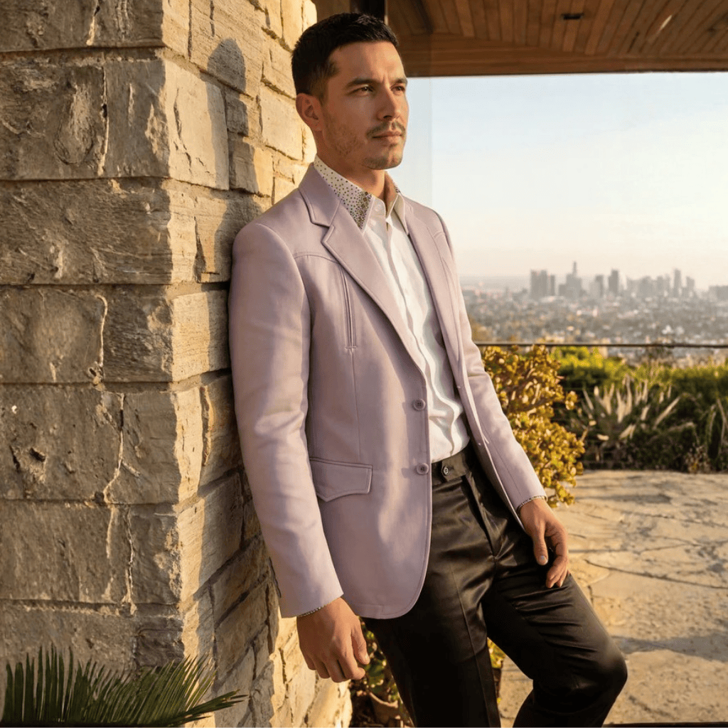 Modelo usando blazer en exterior, posando junto a muro de piedra.