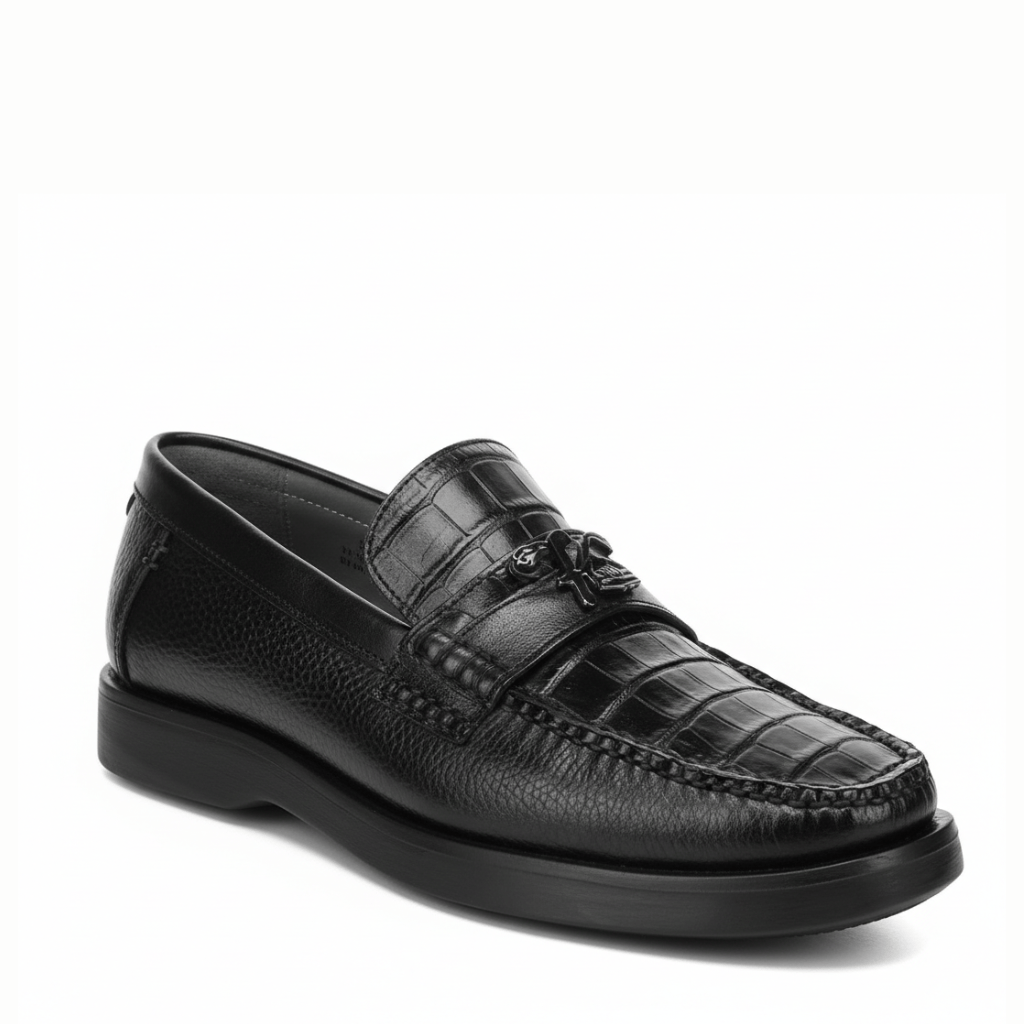 Loafer negro en piel de caimán con textura marcada y suela oscura.
