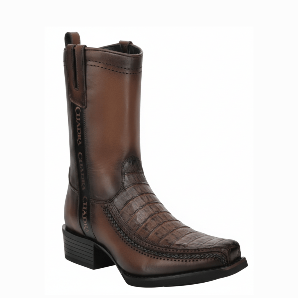 Bota con pala texturizada de caimán y tubo liso, tacón bajo y diseño elegante.