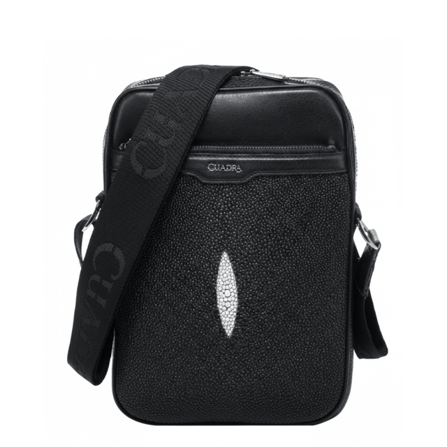 Bolso bandolera negro con textura de mantarraya y detalle central claro.