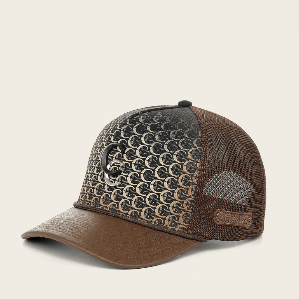 Vista lateral de la gorra mostrando el monograma all-over y logo metálico.