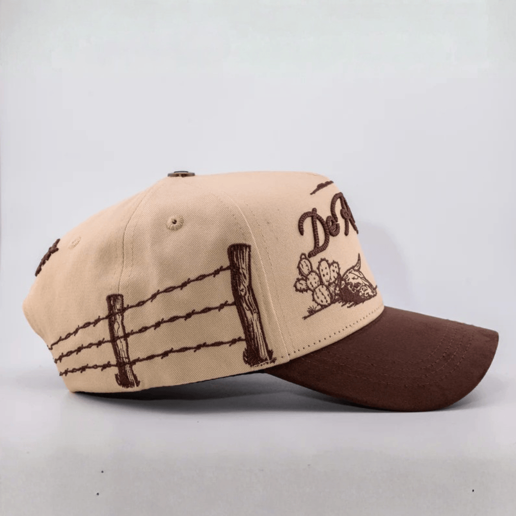 Vista lateral de la gorra mostrando bordados western y diseño café.