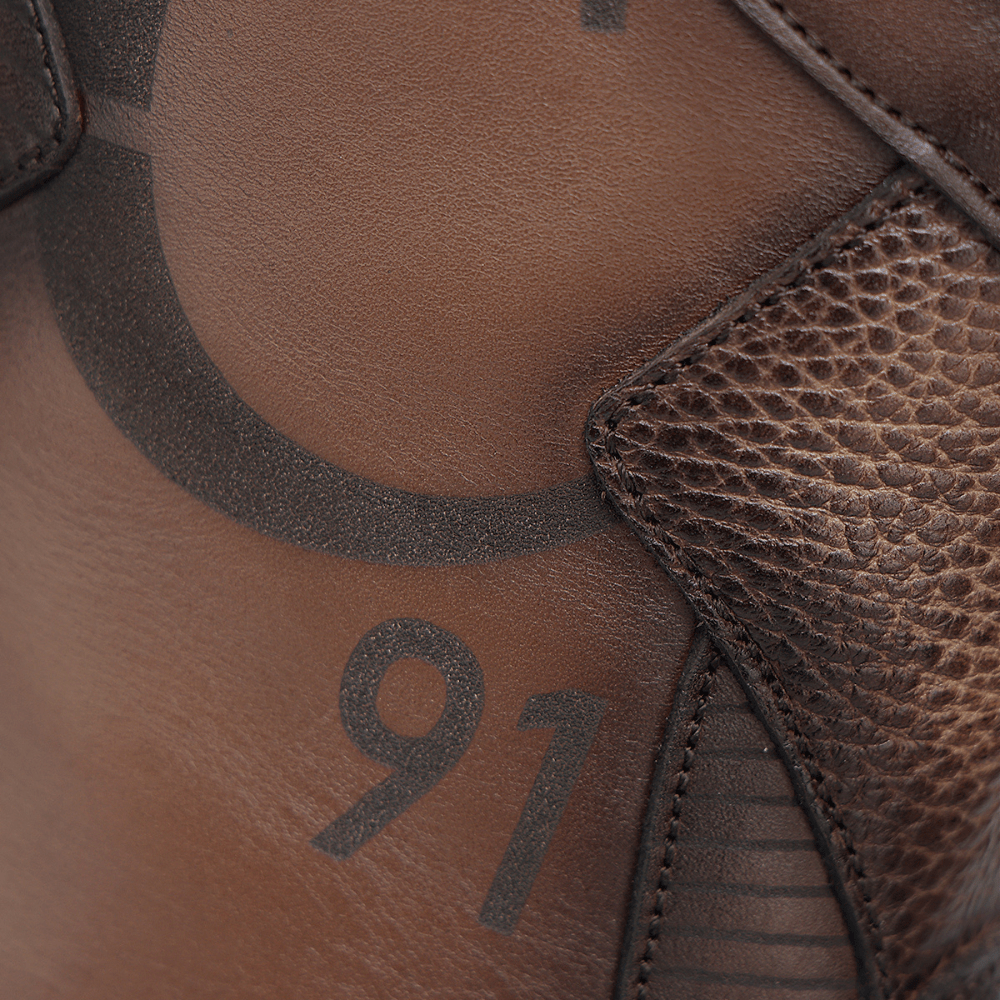 Acercamiento al costado con el número 91 y detalles grabados sobre la piel.