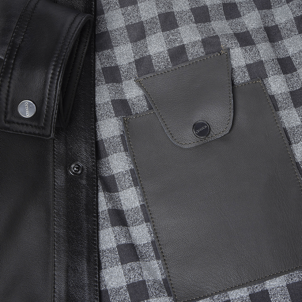 Interior de la chamarra con forro a cuadros y bolsillo de piel con broche.