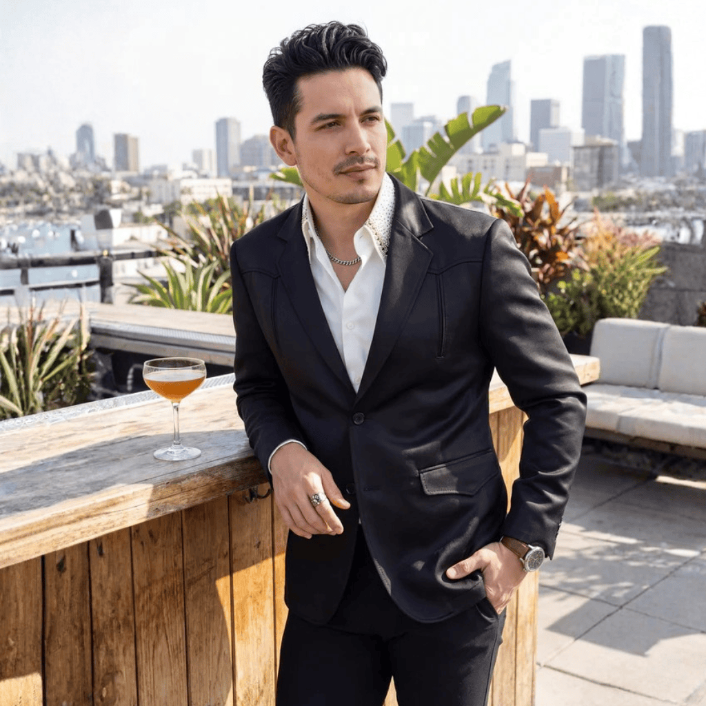 Modelo con traje negro en terraza urbana.
