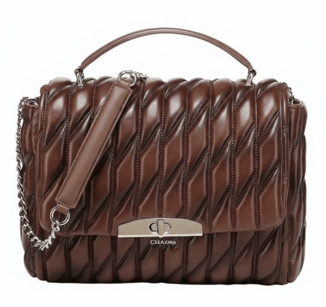 Bolso acolchado con líneas diagonales, herraje metálico frontal.