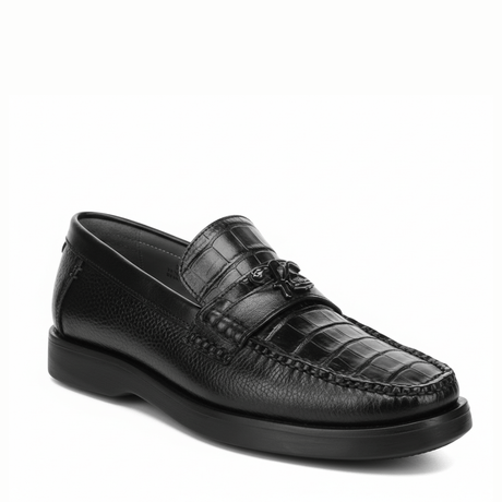 Loafer negro en piel de caimán con textura marcada y suela oscura.