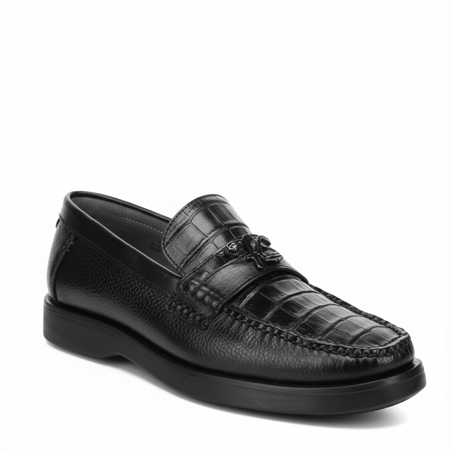 Loafer negro en piel de caimán con textura marcada y suela oscura.