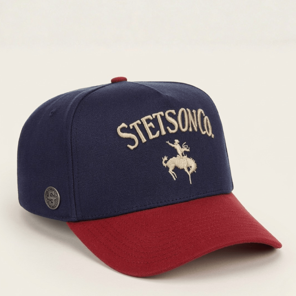 Gorra azul marino con visera roja y bordado frontal de jinete.
