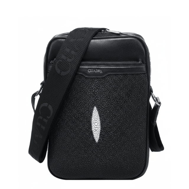 Bolso bandolera negro con textura de mantarraya y detalle central claro.