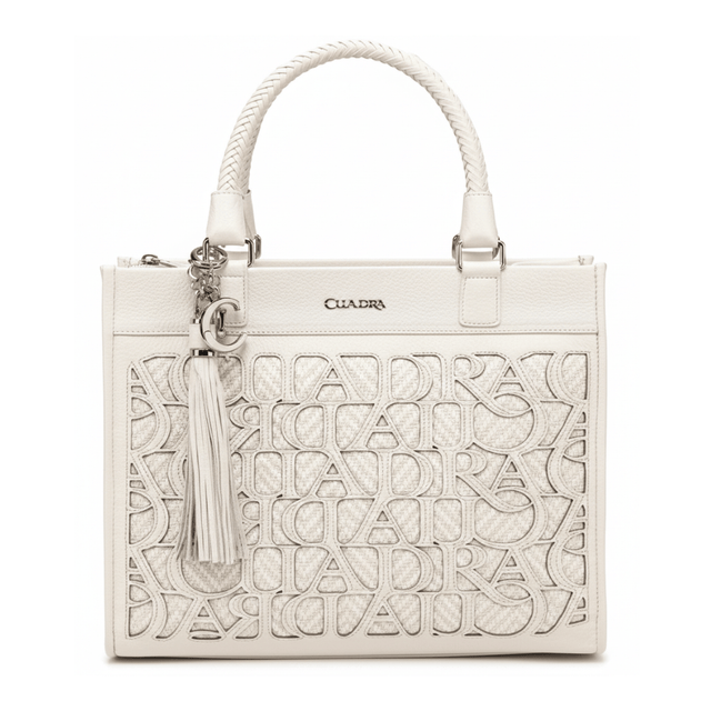 Bolso estructurado con patrón calado frontal, asas trenzadas y dije metálico.