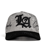 Gorra blanca con bordado grande “LA” al frente.