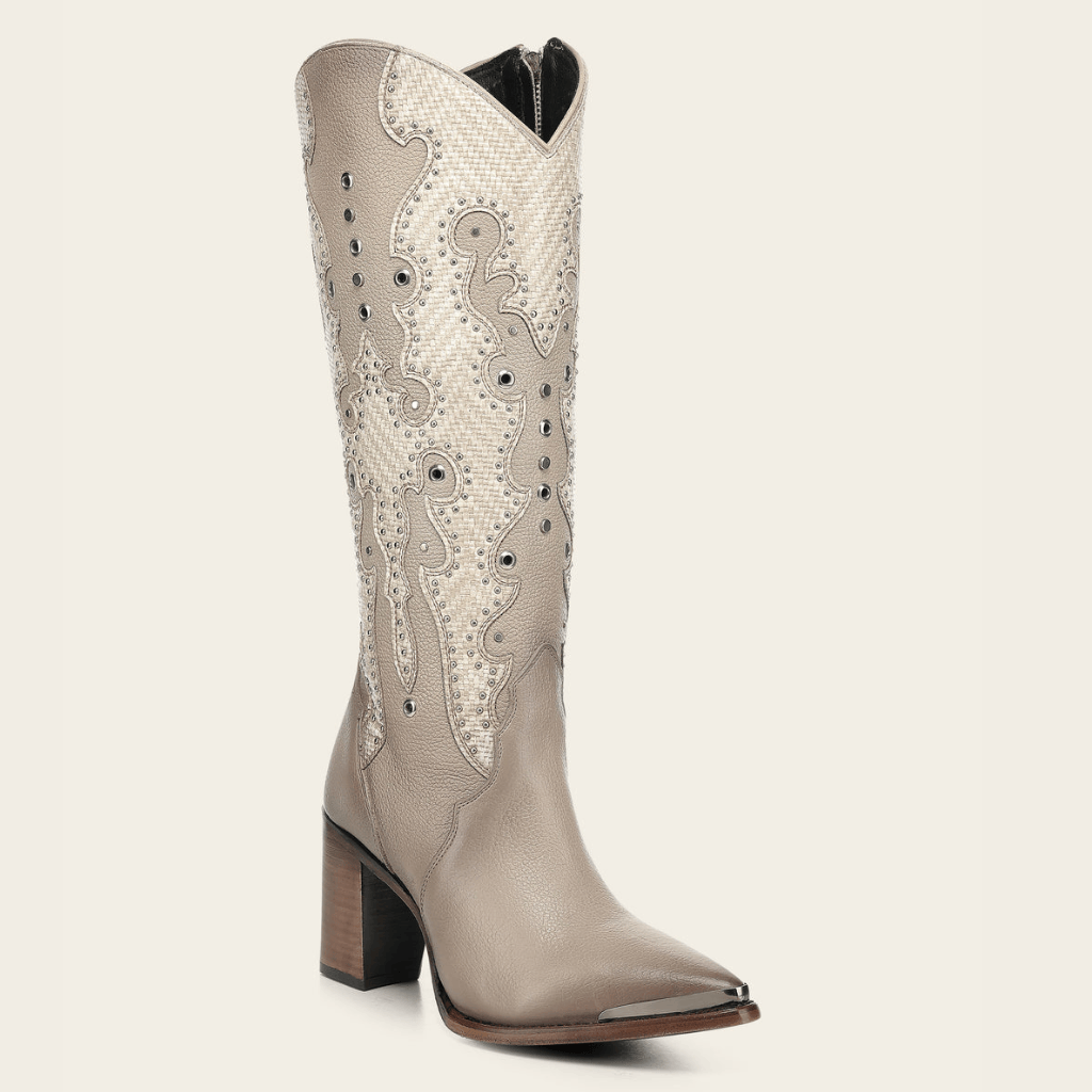 Bota alta beige con bordado y aplicaciones metálicas.