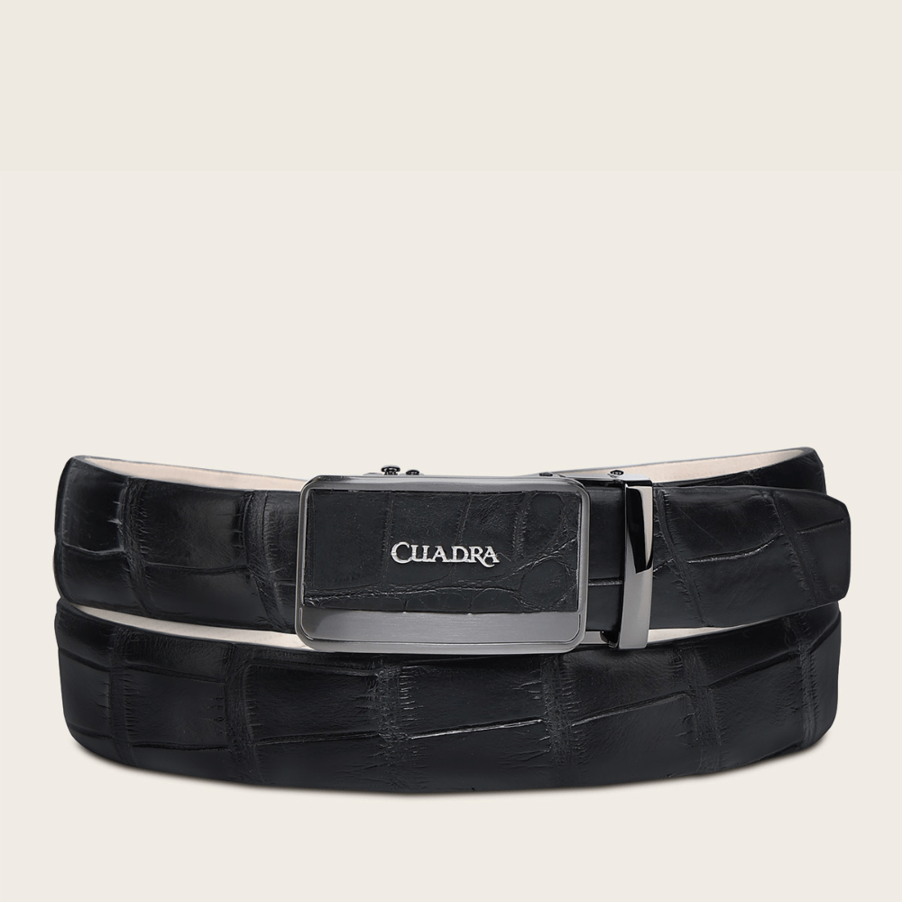 Cinto de piel exotica negra con hebilla metálica rectangular grabada.