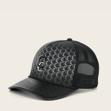 Vista lateral de la gorra mostrando el monograma all-over y logo metálico.