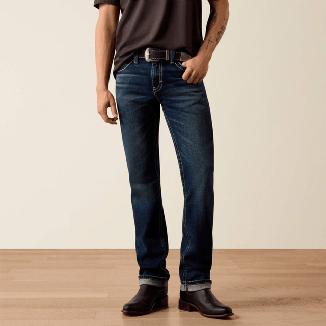 Vista frontal de jeans azul oscuro con botas negras.
