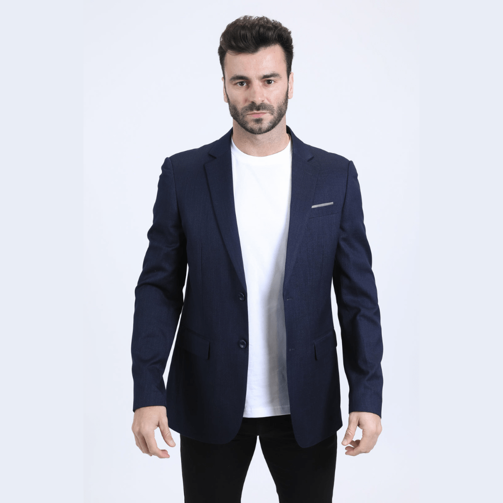 Modelo con saco azul marino y camiseta blanca, estilo moderno.