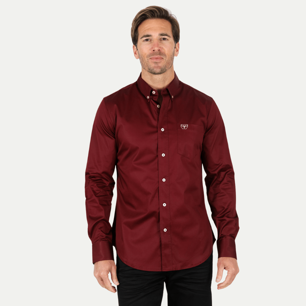 Modelo con camisa vino de manga larga y botones al frente, estilo formal.