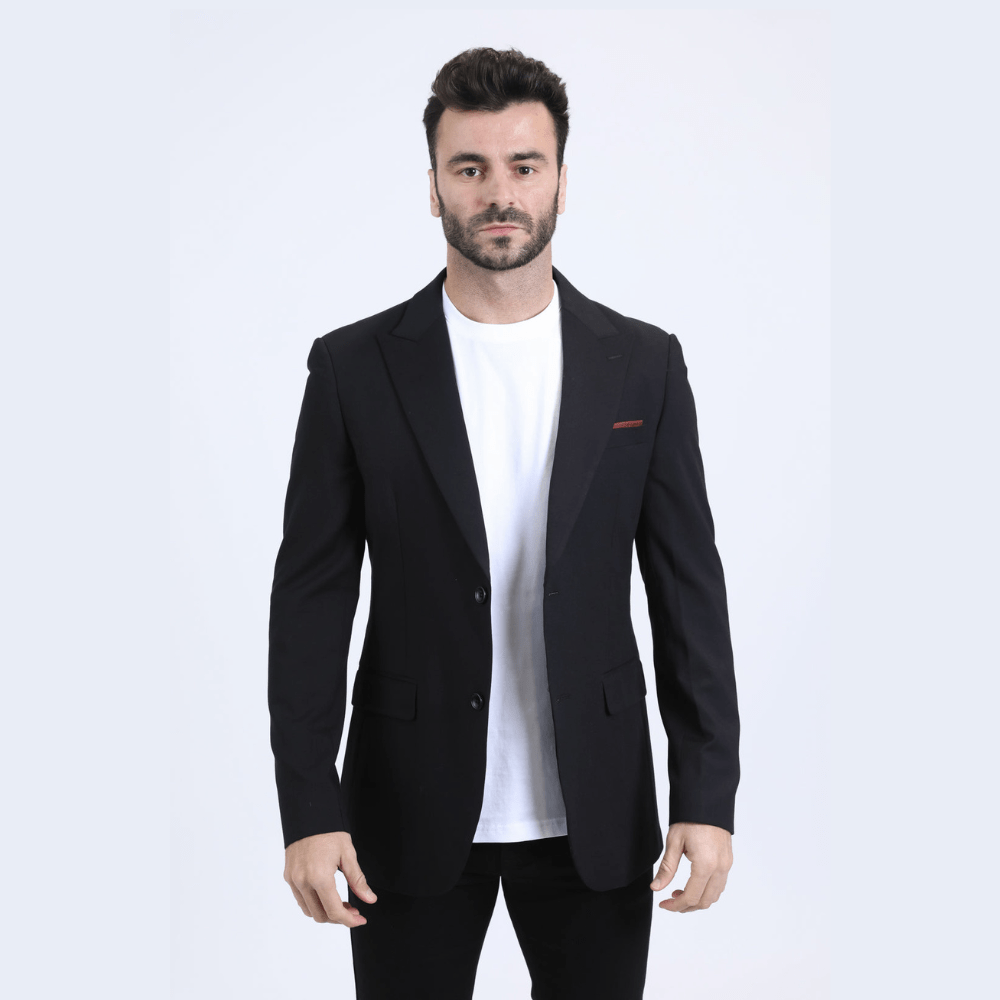 Modelo con saco negro y camiseta blanca, look elegante y moderno.