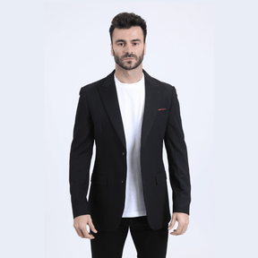 Modelo con saco negro y camiseta blanca, look elegante y moderno.