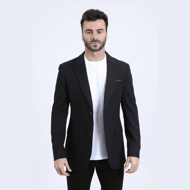 Modelo con saco negro y camiseta blanca, look elegante y moderno.