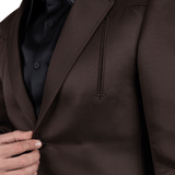 Detalle del blazer café mostrando el bolsillo y el corte frontal.