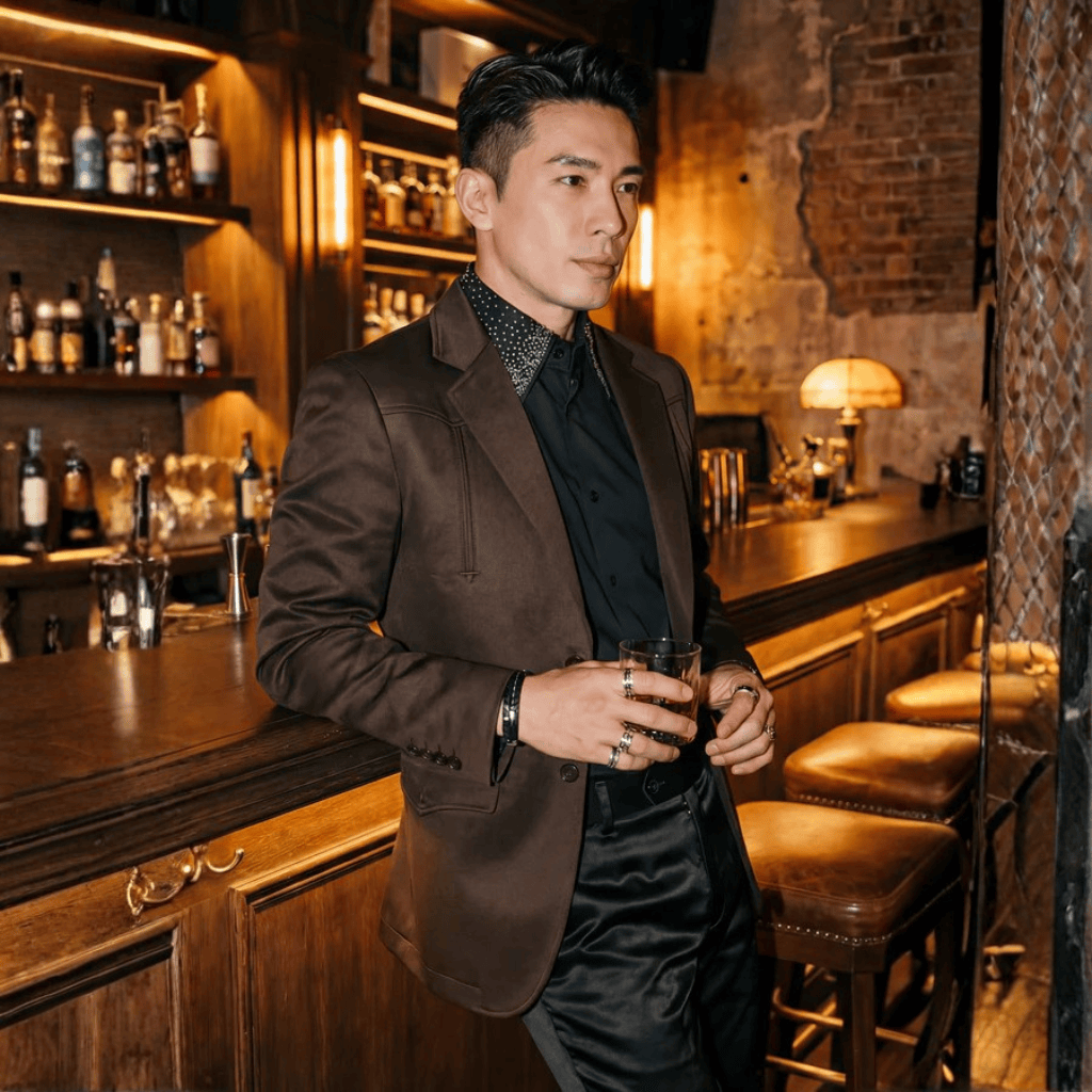 Modelo usando blazer en exterior, posando en ambiente nocturno.