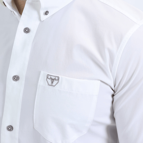 Acercamiento al bolsillo con botón y logotipo bordado en el pecho.