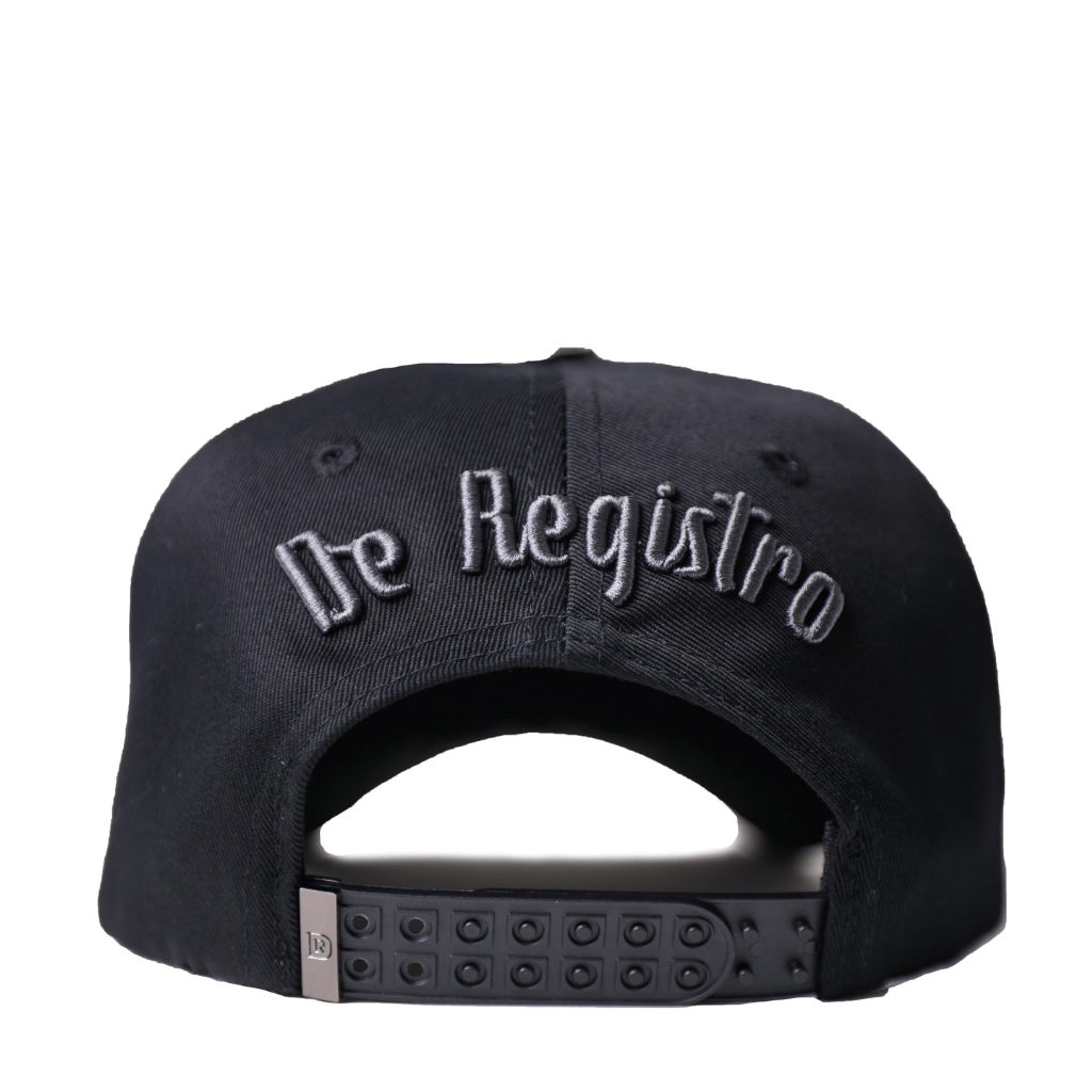 Vista trasera con bordado “De Registro” y cierre snapback.