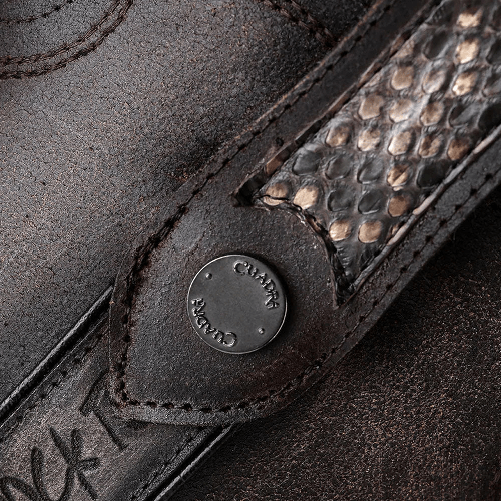 Detalle cercano de la tira lateral en piel de pitón con remache metálico.