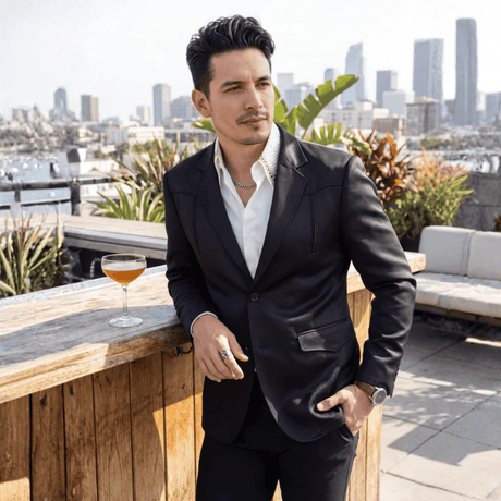 Modelo con traje negro en terraza urbana.