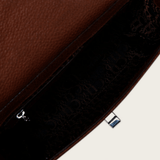 Interior del bolso con forro oscuro estampado y compartimento con cierre.