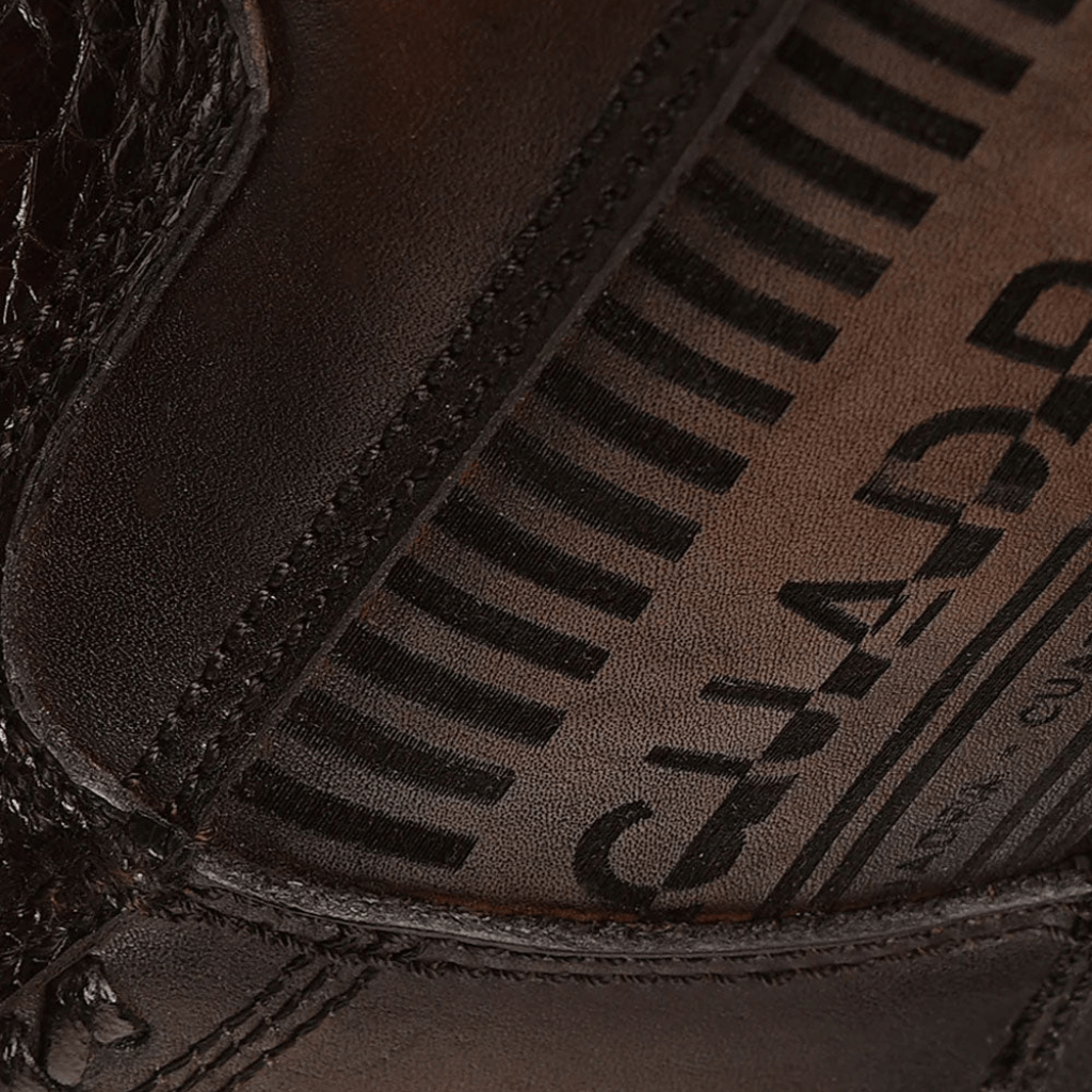 Detalle cercano del cierre y grabado en el cuero.