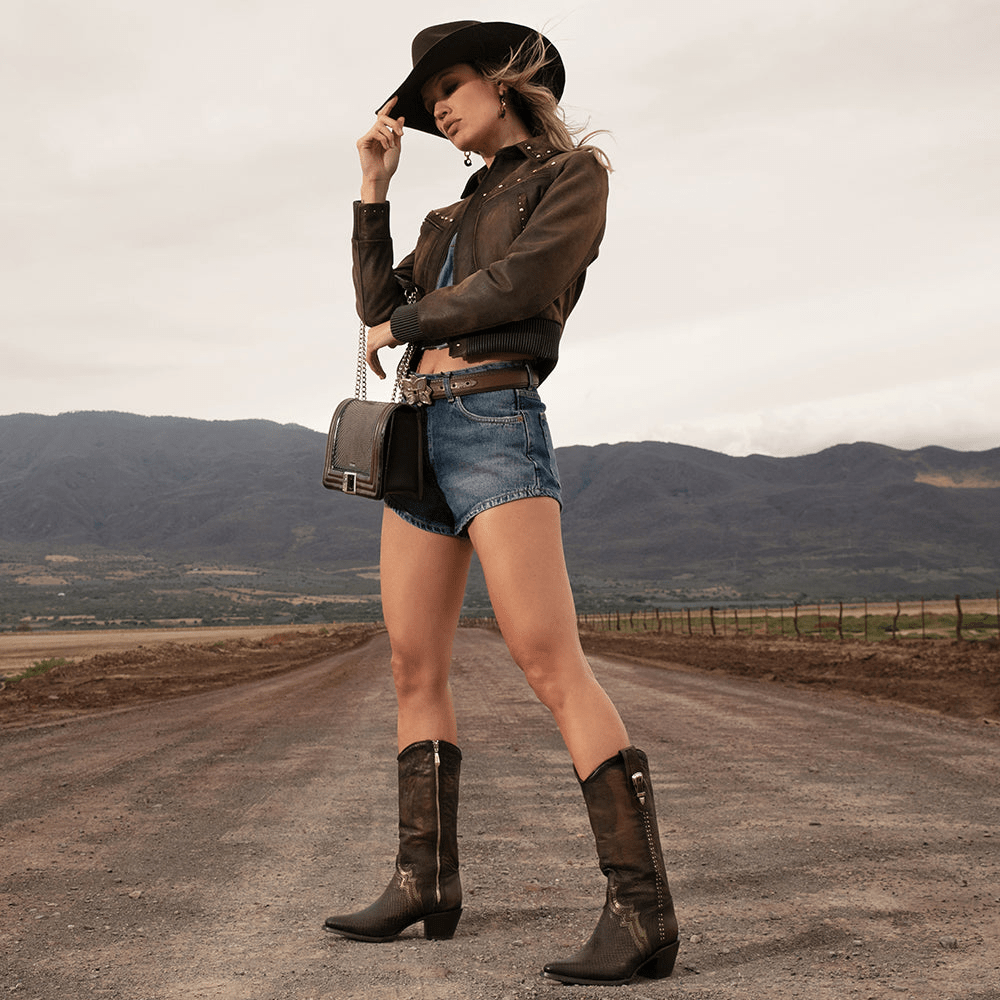 Modelo usando las botas con un look vaquero moderno, con estilo y actitud.