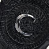 Primer plano del emblema metálico sobre tejido negro.