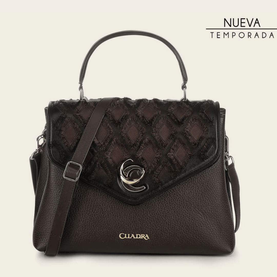 Bolso estructurado con panel superior trenzado y herraje metálico central.