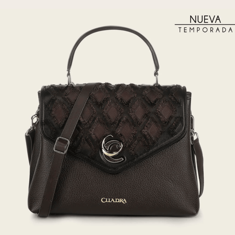 Bolso estructurado con panel superior trenzado y herraje metálico central.