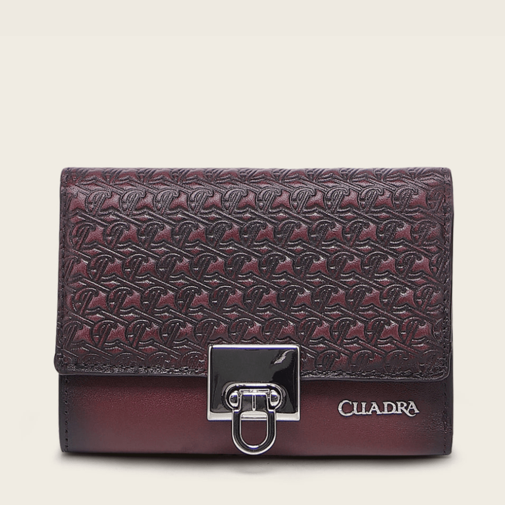 Billetera de piel color vino con diseño grabado y broche metálico frontal.