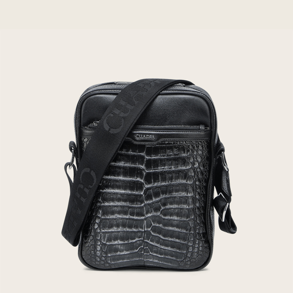 Bandolera negra de piel con textura tipo cocodrilo con el logo “Cuadra”.