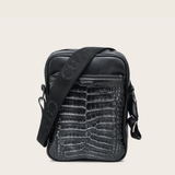 Bandolera negra de piel con textura tipo cocodrilo con el logo “Cuadra”.