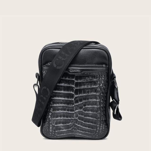 Bandolera negra de piel con textura tipo cocodrilo con el logo “Cuadra”.